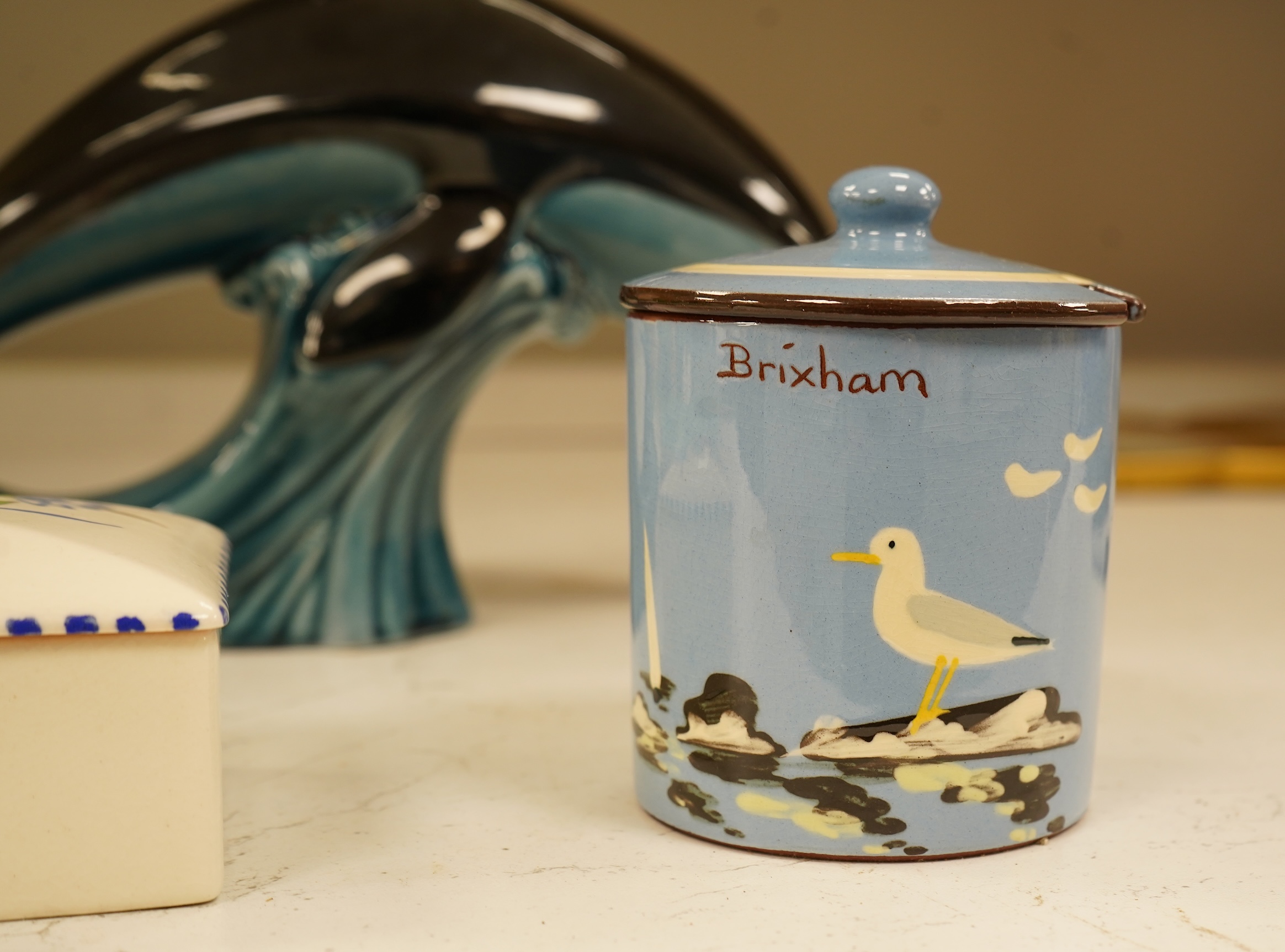 A Poole Pottery hors d’ouevres dish, a dolphin, a box and cover and a Torquay ware Brixham jar